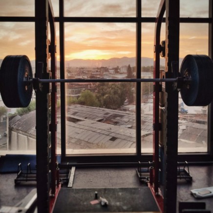 You don't need a rack to squat. In calisthenics you can bodyweight squat also at home.